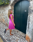 Black kitten heel sandals worn with a pink dress