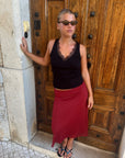 Black kitten heel sandals worn with a red skirt