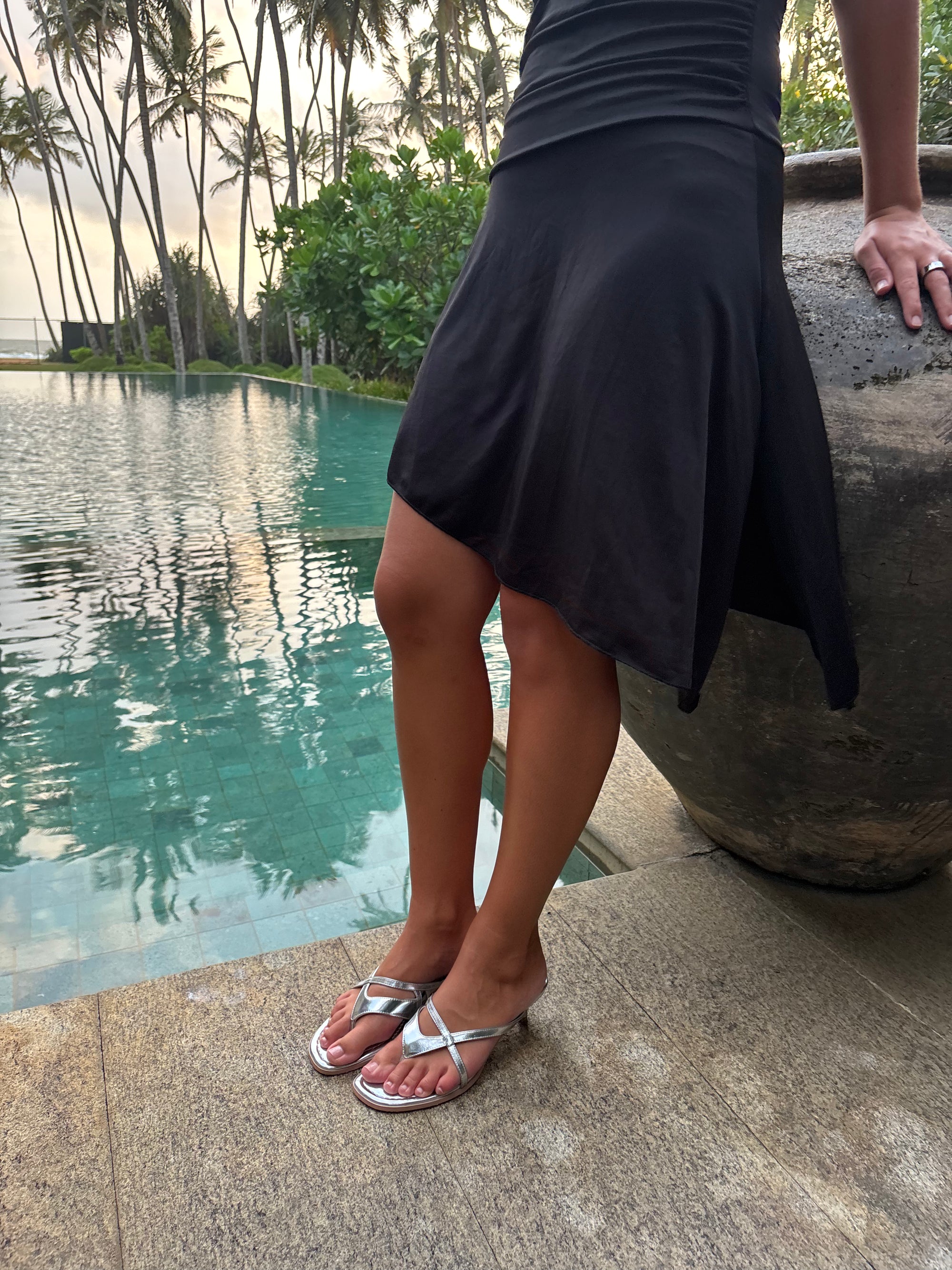Silver kitten heel sandals worn beside a pool