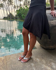 Silver kitten heel sandals worn beside a pool