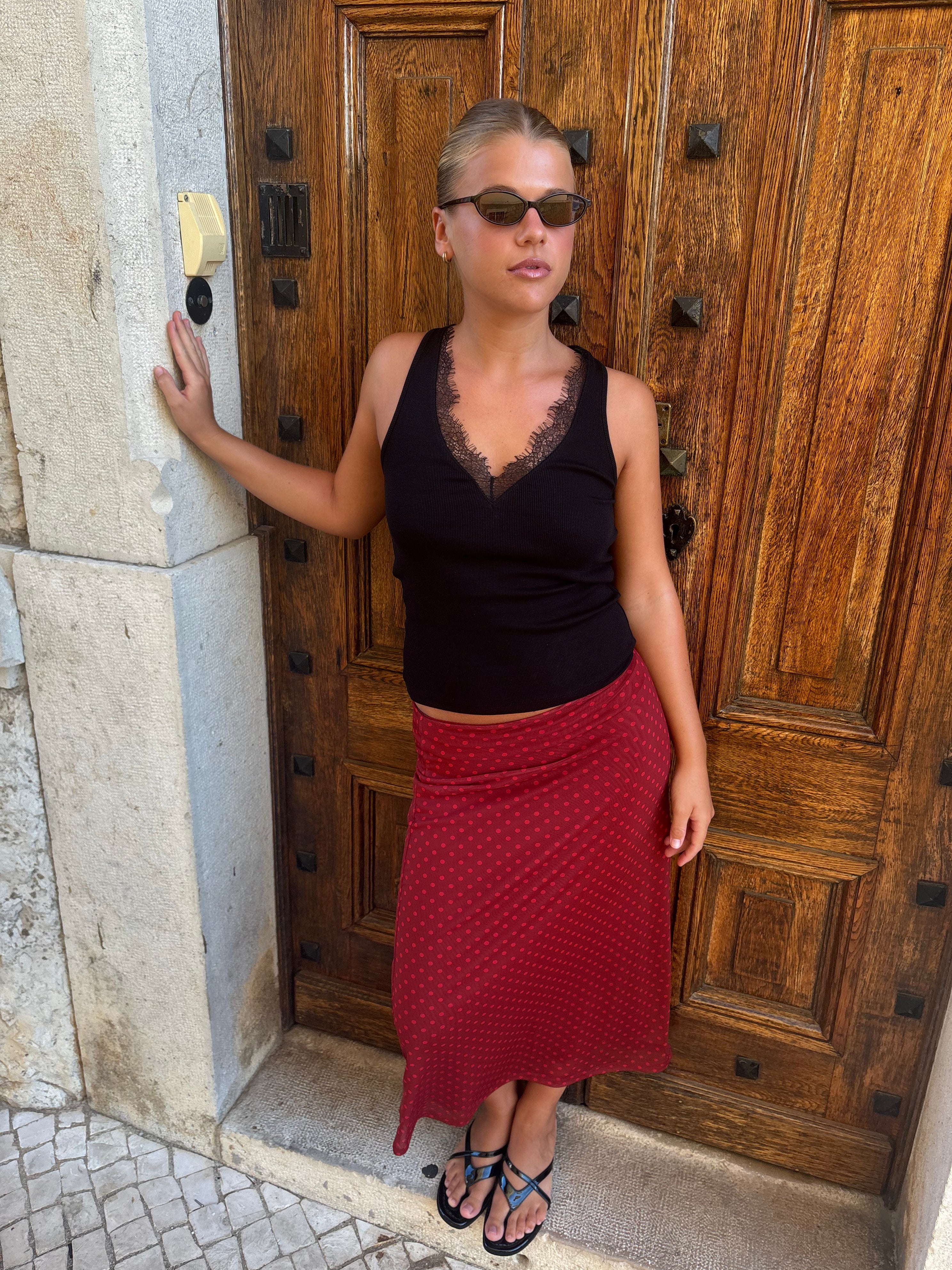 Black kitten heel sandals worn with a red skirt